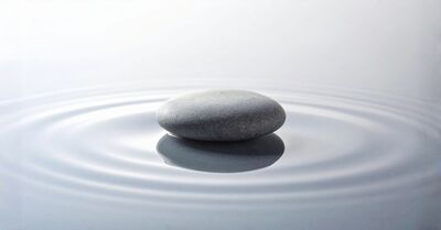Smooth stone creating gentle water ripples